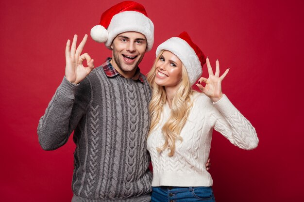 Retrato de una joven pareja alegre en sombreros de Navidad