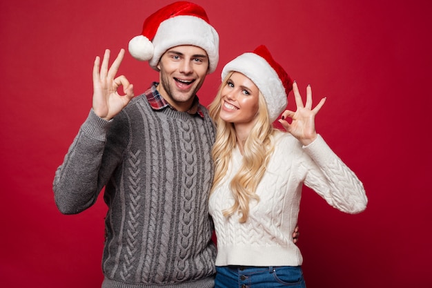 Retrato de una joven pareja alegre en sombreros de Navidad