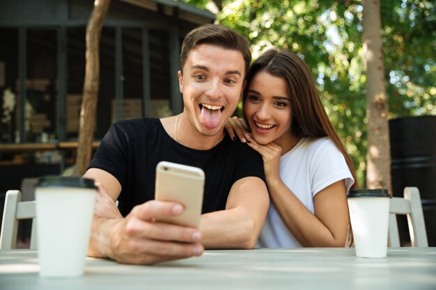 Retrato de una joven pareja divertida tomando selfie