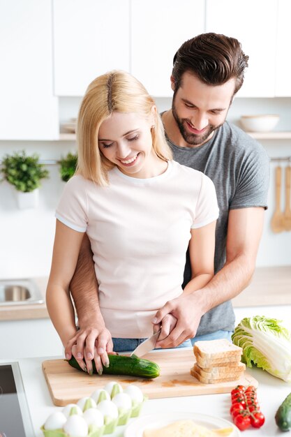 Retrato de la joven pareja feliz cocinando juntos en la cocina