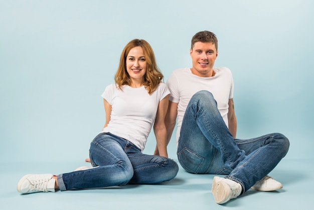 Retrato de una joven pareja feliz contra el fondo azul