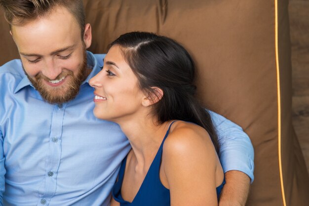 Retrato de la joven pareja feliz descansando en el sofá