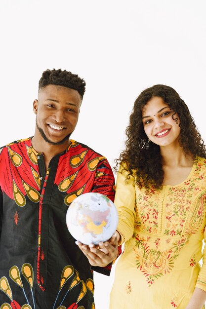 Retrato de una joven pareja, mujer india y hombre africano con globo. Aislado sobre fondo blanco.