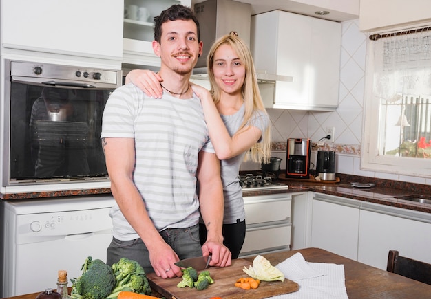 Foto gratuita retrato de joven pareja de pie en la cocina