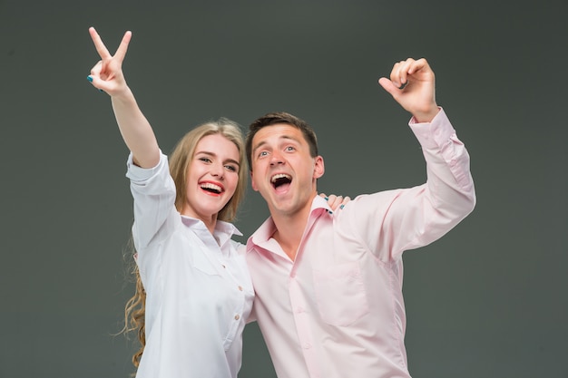 Foto gratuita retrato de una joven pareja de pie en gris