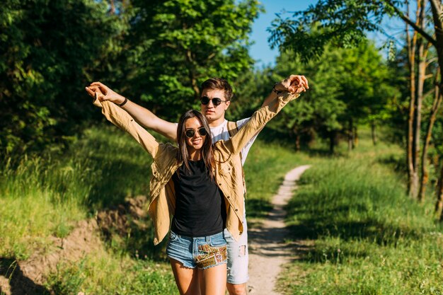 Retrato de joven pareja de senderismo extendiendo sus manos