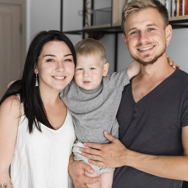 Retrato de la joven pareja sonriente con su pequeño hijo