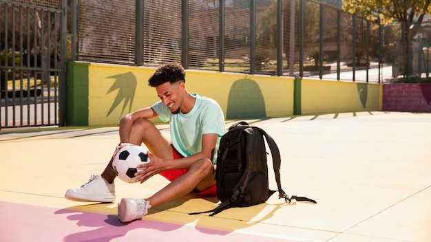 Foto gratuita retrato joven con pelota de fútbol