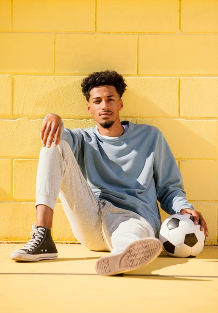 Foto gratuita retrato joven con pelota de fútbol