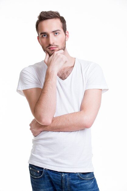 Retrato del joven pensante en casual aislado sobre fondo blanco.