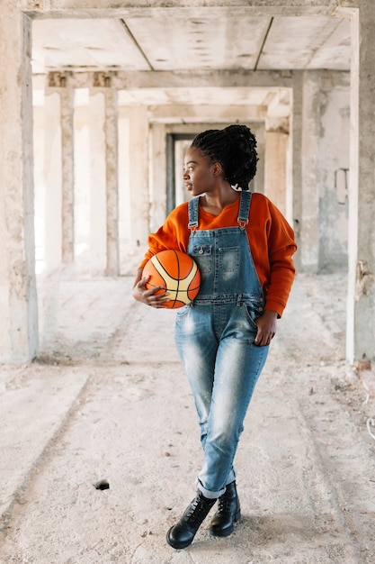 Retrato de joven posando con pelota de baloncesto