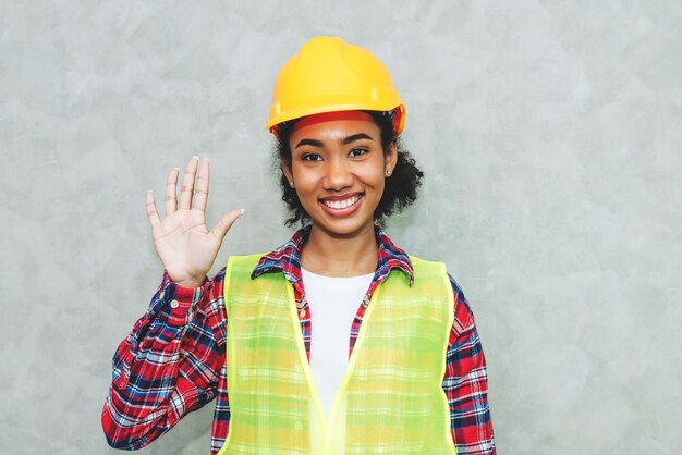 Retrato de una joven profesional negra que trabaja en la arquitectura del ingeniero civil con casco de seguridad para trabajar en el sitio de construcción o en el almacén