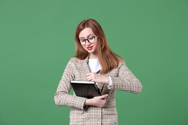 Retrato de joven profesora con bloc de notas en verde