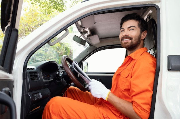 Retrato de joven repartidor preparándose para arrancar el coche