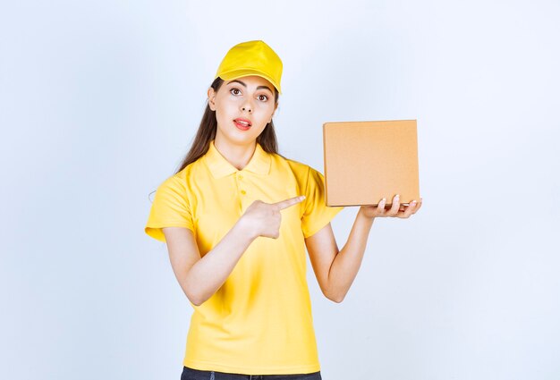 Retrato de joven repartidora sosteniendo una sola caja en blanco.