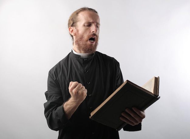 Foto gratuita retrato de un joven sacerdote mientras recita versos de la biblia