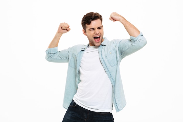 Retrato de un joven satisfecho celebrando el éxito