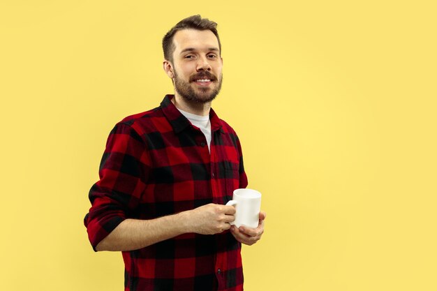 retrato, de, joven, en, shirt., vista delantera. Colores de moda. De pie con una taza.