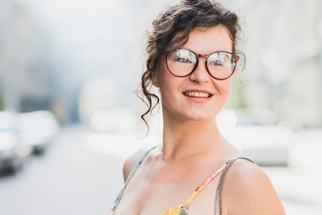 Foto gratuita retrato de una joven sonriente con anteojos