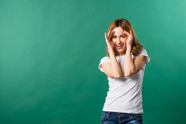 Retrato de una joven sonriente contra el telón de fondo verde