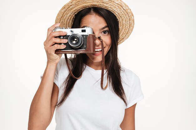 Retrato de una joven sonriente en pie de sombrero