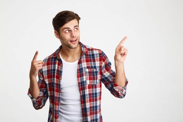 Retrato de un joven sonriente señalando