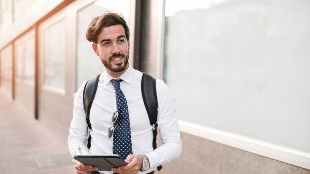 Retrato de un joven sonriente con tableta digital