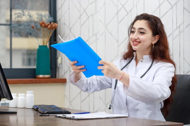 Retrato de joven sonriente trabajador de la salud con análisis