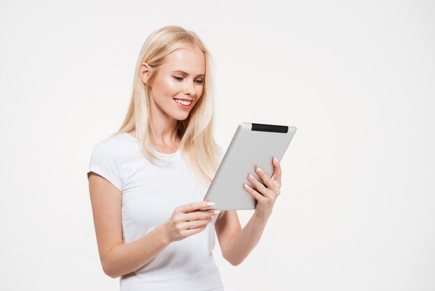 Retrato de una joven sonriente trabajando en tableta