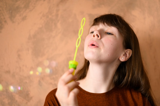 Foto gratuita retrato de joven soplando burbujas