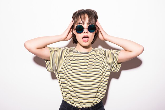 Retrato de una joven sorprendida gafas de sol mirando con la boca abierta aislada