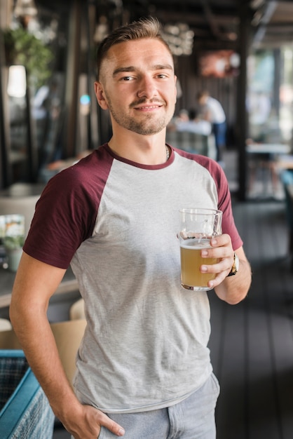 Retrato de un joven sosteniendo un vaso de cerveza