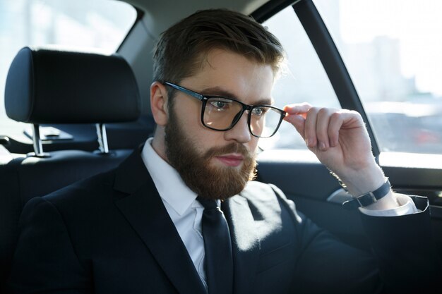 Retrato de un joven srious vistiendo traje y anteojos