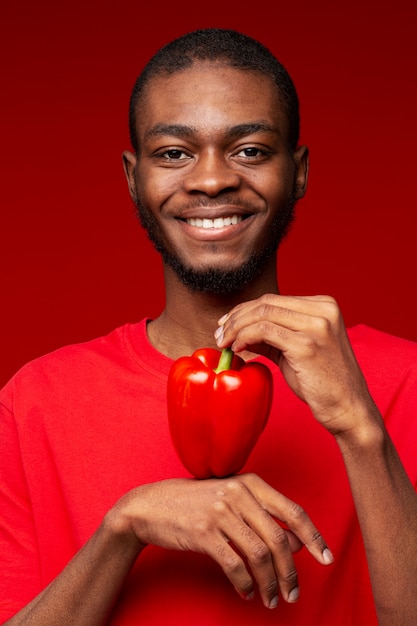 Foto gratuita retrato, de, joven, tenencia, pimiento rojo