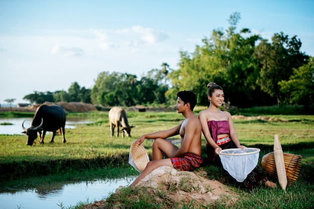 Retrato de joven en topless sentado cerca de una mujer bonita en ropa hermosa en el estilo de vida rural