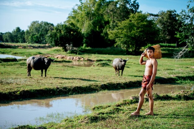 Retrato joven topless utilizar trampa de pesca de bambú para atrapar peces para cocinar