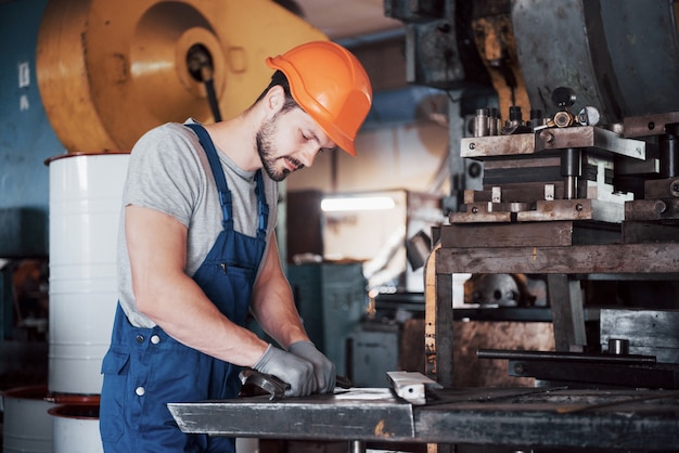 Retrato de un joven trabajador con un casco en una gran fábrica de reciclaje de residuos.