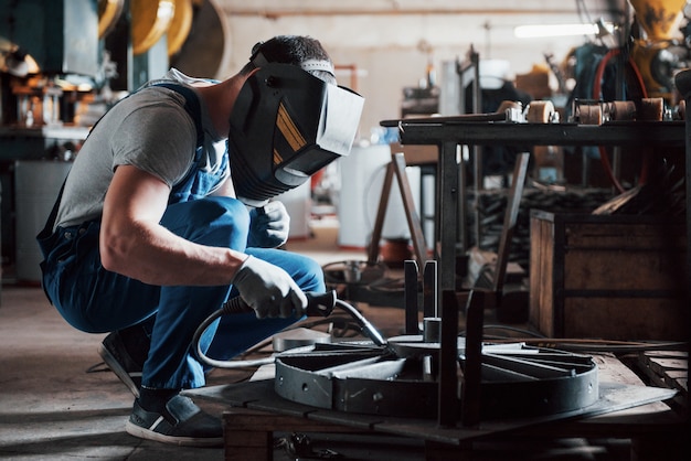 Foto gratuita retrato de un joven trabajador en una gran planta metalmecánica.