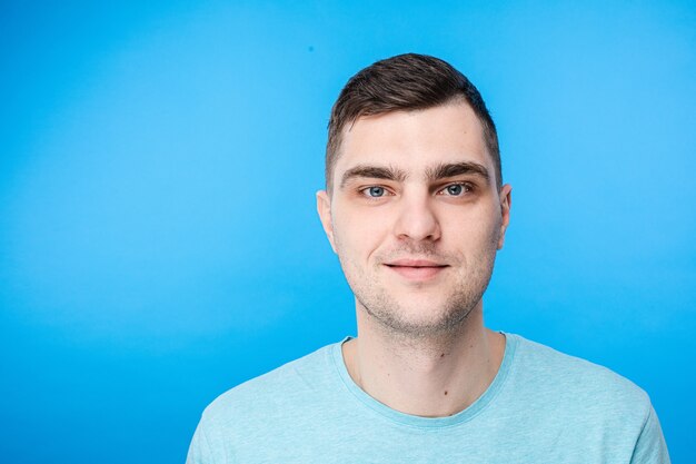 Retrato de joven varón caucásico con pelo corto oscuro y cara bonita es feliz