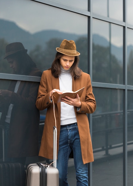 Foto gratuita retrato de joven viajero leyendo