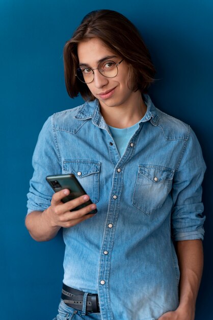 Retrato de jovencito fresco comprobando su teléfono