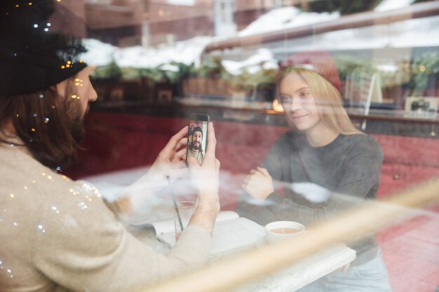 Retrato de jóvenes hipsters en café detrás del cristal