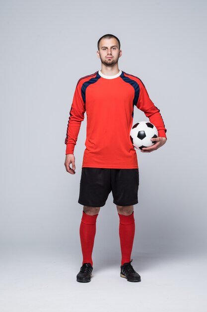Retrato de jugador de fútbol profesional en camisa roja aislado en blanco
