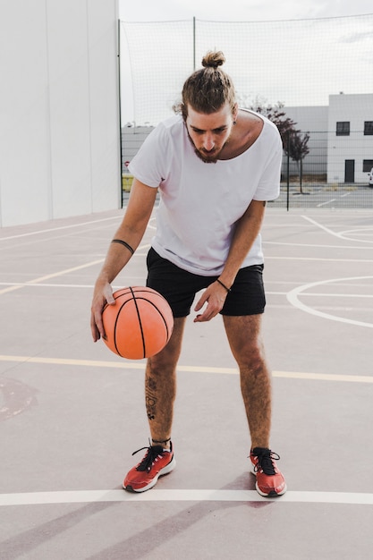 Retrato de un jugador regateando baloncesto.