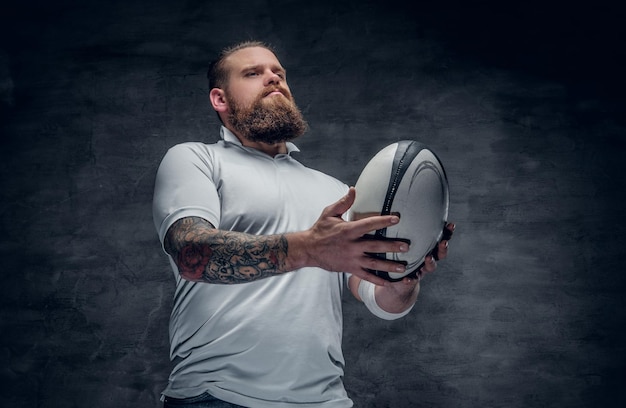 Retrato de jugador de rugby barbudo con tatuajes en los brazos