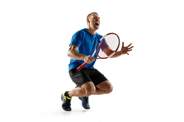 Foto gratuita retrato de un jugador de tenis masculino guapo celebrando su éxito aislado en una pared blanca. las emociones humanas, ganador, deporte, concepto de victoria