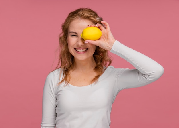 Retrato juguetón mujer sosteniendo limones y risas