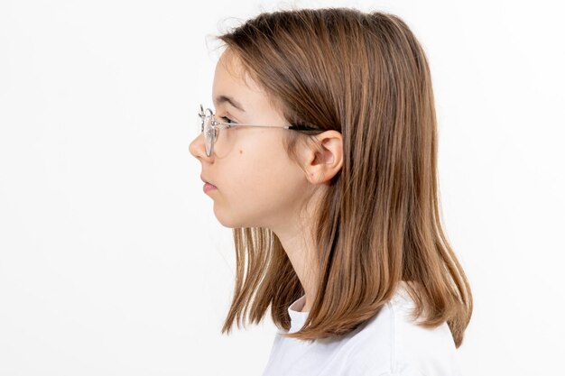 Retrato lateral de una niña con gafas aisladas sobre un fondo blanco