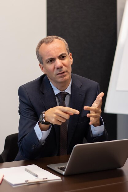 Retrato de líder empresarial hablando de asuntos. Hombre serio y estricto discutiendo con los empleados proyectos futuros, estrategia de planificación. Ideas de negocio y concepto de estrategia de crecimiento.