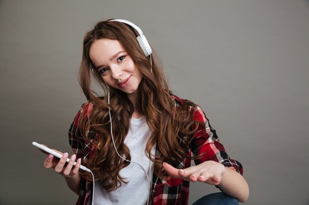 Retrato de una linda chica adolescente escuchando música con auriculares